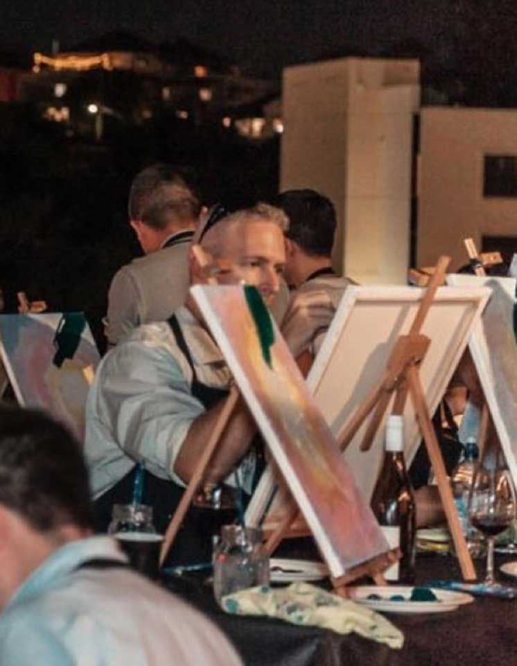 men painting and drinking at an outdoor mobile pop-up event with Pinot and Picasso