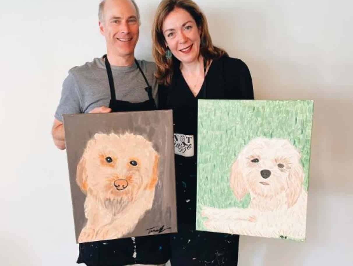Paint your pet artwork is the most popular artwork at Pinot & Picasso. A man and a woman hold the artworks they painted of their dogs