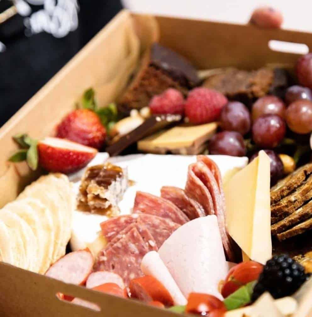 cheese, meat, strawberries, biscuits and fruit in a grazing box