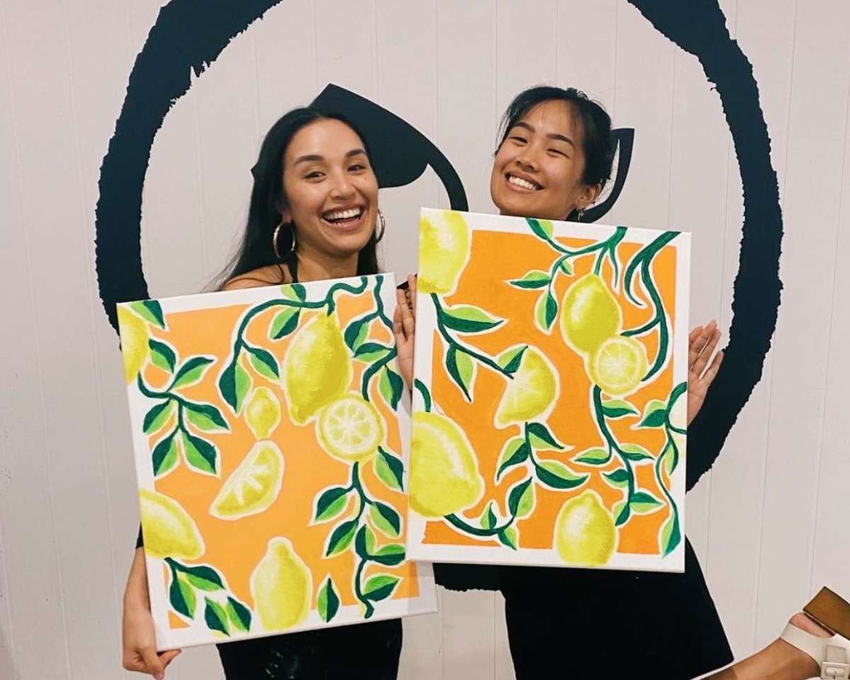 two women happy with their artwork of lemons at Pinot & Picasso